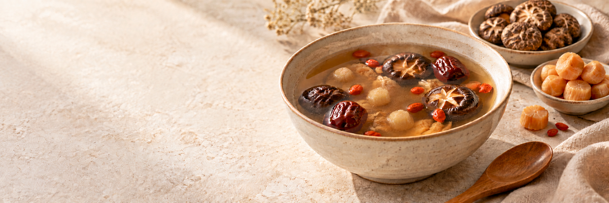Chinese soup with scallops, shiitake mushrooms, red dates and goji berries on a warm stone kitchen counter